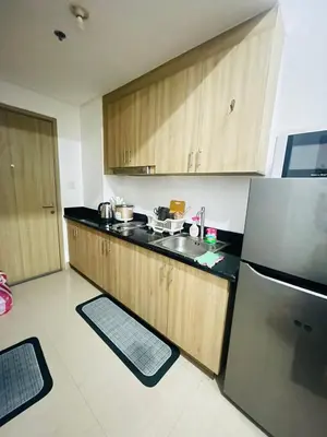 a kitchen with wooden cabinets and a stainless steel refrigerator at H&M condotel in Manila