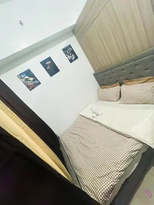 a bed in a room with pictures on the wall at H&M condotel in Manila