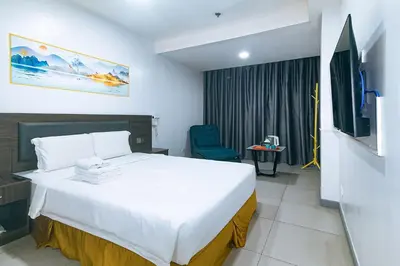 a hotel room with a bed and a tv at Luna Hotel by RedDoorz near MOA in Manila