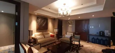 a living room with a couch and a chandelier at Shell Residences Condominium Philippines, Manila, Pasay City in Manila