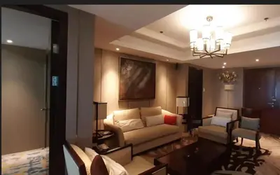 a living room with a couch and a chandelier at Shell Residences Condominium Philippines, Manila, Pasay City in Manila