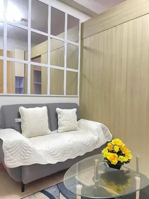 a living room with a couch and a glass table at Transient Home Lancin in Manila