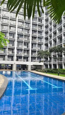 a large apartment building with a large blue swimming pool at Urban Haven Manila in Manila