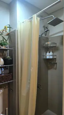 a shower with a white shower curtain in a bathroom at Urban Haven Manila in Manila