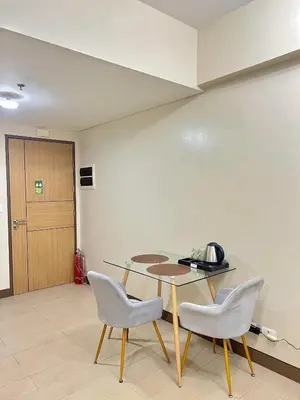 a dining room with a table and two chairs at CONDOTEL - Across NAIA T3 Airport with WIFI in Manila