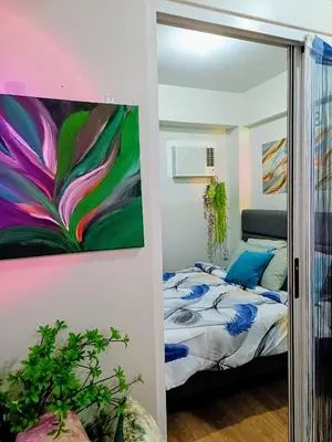 a bedroom with a bed and a painting on the wall at The Atherton Condominium 1 Bedroom Staycation in Manila