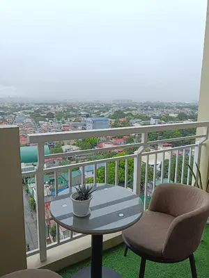 a table and chairs on a balcony with a view at The Atherton Condominium 1 Bedroom Staycation in Manila