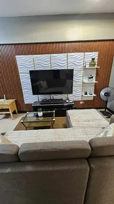 a living room with a couch and a flat screen tv at Condotels by Macobs in Manila