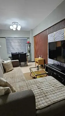 a living room with a couch and a flat screen tv at Condotels by Macobs in Manila