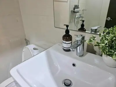 a bathroom sink with a bottle of wine on it at Elegant Central 1BR BGC 11P Uptown Parksuites T2 in Manila