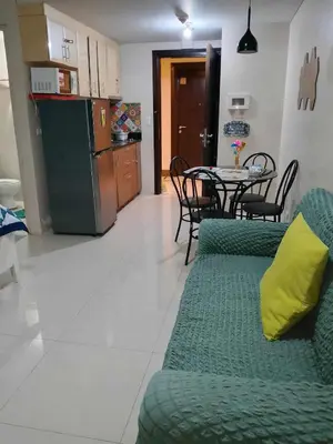 a living room with a green couch and a table at Neri Ann's Comfort Escape in Manila