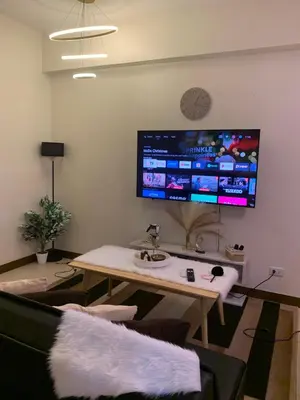a living room with a table and a large tv on the wall at 2BR 38th flr SIESTA SPACE in PRISMA Residences in Manila
