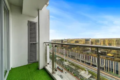 a balcony with a view of a train yard at Elegant Studio City View near Airport, City of Dreams, Okada, Solaire, PARQAL, Ayala Malls, and MOA in Manila