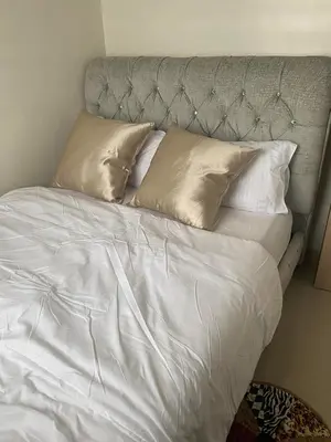 a bed with white sheets and pillows at Leaf Residences in Muntinlupa