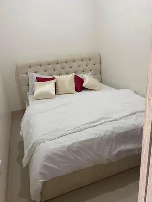 a large white bed with four pillows on it at 2 bedroom condo at Leaf Residences Muntinlupa in Manila