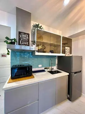 a kitchen with a sink and a black refrigerator at Guest House Ground Zero in Manila