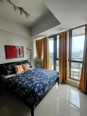 a bedroom with a bed and a large window at Lowest Room Rate in Makati with fast wifi & view in Manila