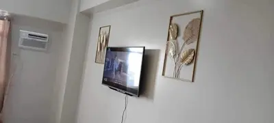 a flat screen tv hanging on a wall with pictures at Condotels by Versola in Manila