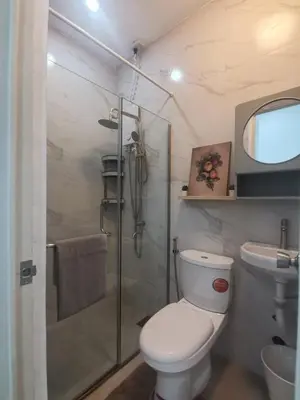 a bathroom with a toilet and a glass shower at Ikea inspired home with mini balcony and free parking in Cainta