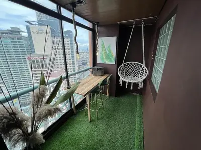 a balcony with a table and a swing in a building at Benedict's Staycation in Manila