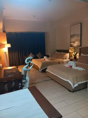 a hotel room with two beds and a table at Spacious Studio 3B C5 in Manila
