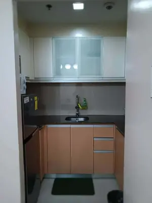 a small kitchen with white cabinets and a sink at Spacious Studio 3B C5 in Manila