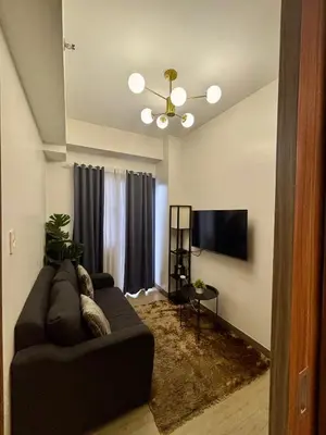 a living room with a couch and a flat screen tv at Casa Kanlungan at Spring Residences Tower 3 in Manila