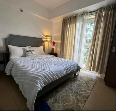 a bedroom with a large bed and a window at NAIA TERMINAL 3 Condo Rentals in Manila