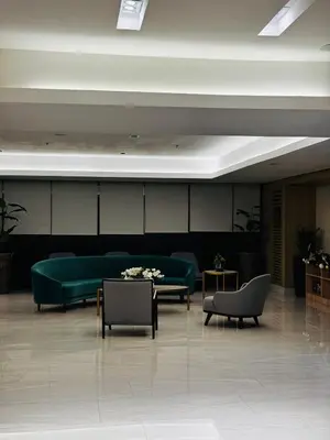 a lobby with a green couch and tables and chairs at Melscape Lush Residence 1BR Unit in Sampong