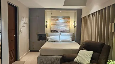 a hotel room with a bed and a couch at One Bedroom Premier at Eastwood Global Plaza Luxury Residences in Manila