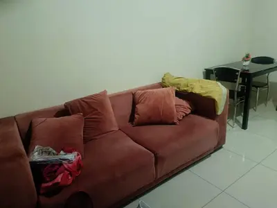 a brown leather couch with pillows and a table at Sea Residences peya in Manila
