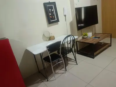 a room with a table and two chairs and a television at Sea Residences peya in Manila