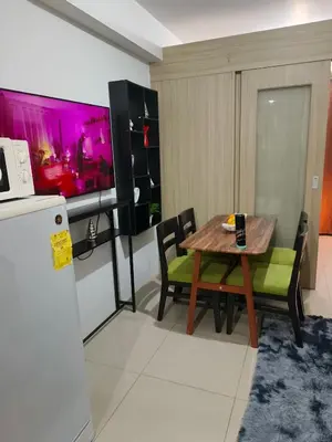 a kitchen and dining room with a table and a refrigerator at Shore Recidences Mall Of Asia Chullen in Manila