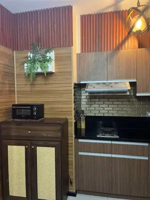 a kitchen with wooden cabinets and a counter top at Modern 1BR Condo in Pasay With Balcony City View Free Swimming Pool Near NAIA Airport, PICC, CCP, MOA in Manila