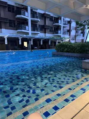 a swimming pool in front of a building at Modern 1BR Condo in Pasay With Balcony City View Free Swimming Pool Near NAIA Airport, PICC, CCP, MOA in Manila