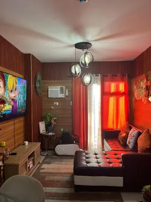 a living room with a couch and a tv at Modern 1BR Condo in Pasay With Balcony City View Free Swimming Pool Near NAIA Airport, PICC, CCP, MOA in Manila