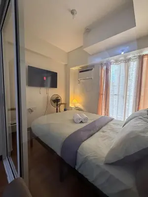 a bedroom with a large bed with two towels on it at Cozy Home with a great view in Manila
