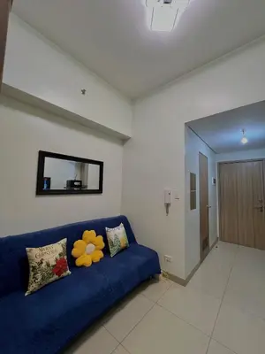 a blue couch in a living room with a mirror at Airport-side Shore Staycation in Manila