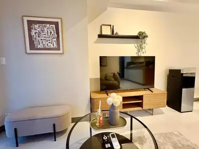 a living room with a tv and a glass table at Luxury-Styled 2BR Uptown T2 Parksuites BGC in Manila