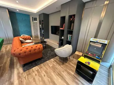 a living room with a couch and a video game at Sofi Staycation- Aurora Escalades in Manila
