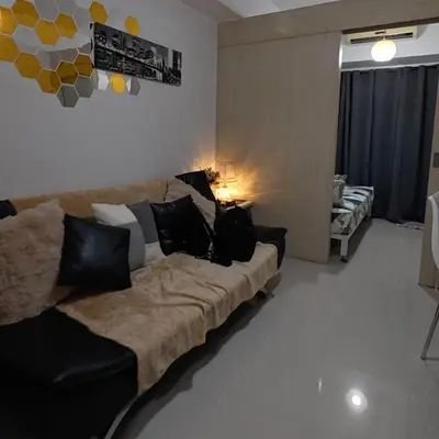 a living room with a couch with pillows on it at MOA Staycation - Sea Residences - Tower C in Manila