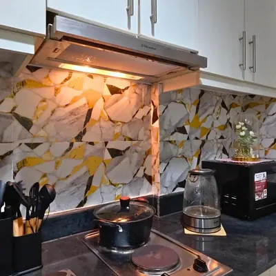 a kitchen with a stove top with a stone wall at MOA Staycation - Sea Residences - Tower C in Manila