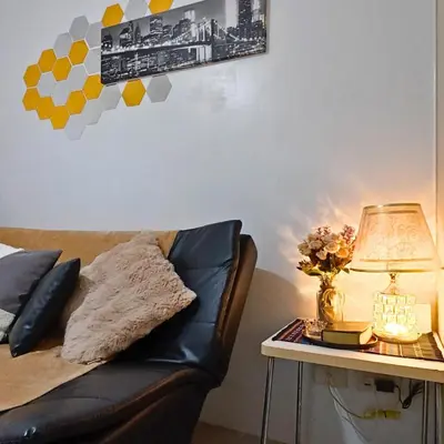 a black leather couch sitting next to a table with a lamp at MOA Staycation - Sea Residences - Tower C in Manila