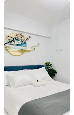 a bedroom with a bed with a painting on the wall at NAIA Terminal 3 Kaydren Airport Suite I Walk to Casino & Mall l 9-mins to Naia l Modern Stay 1 Bedroom in Manila