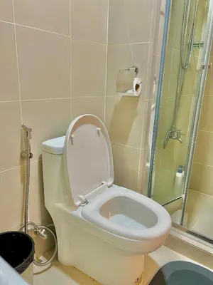 a bathroom with a toilet with a glass shower at Kabina Suites at Fame Residences in Manila