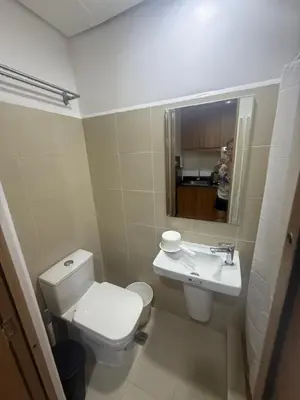 a bathroom with a white toilet and a sink at The Vibe at SMDC The Lush Residences in Manila