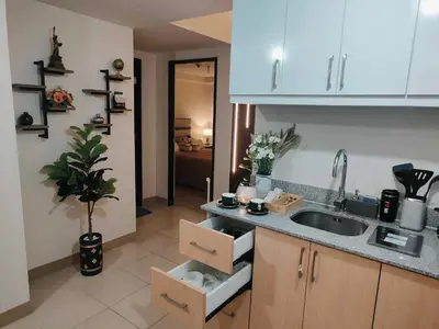 a kitchen with white cabinets and a sink with boxes at Jpad Suites in Manila