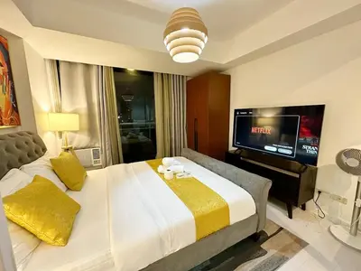 a bedroom with a large bed and a flat screen tv at 1BR Condotel in Azure Urban Resort near NAIA #TRO4 in Manila