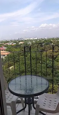 a glass table and chairs on a balcony with a view at CJ Chateau Elysse in Manila