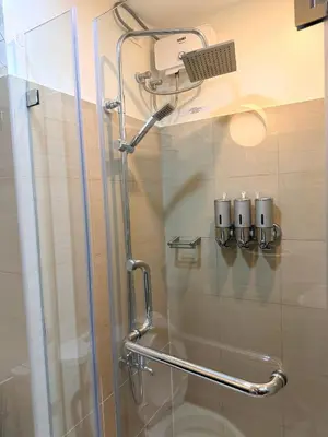 a shower with a glass door in a bathroom at Relaxing 1BR Condo near MOA & NAIA with WiFi, PS4, Karaoke in Manila